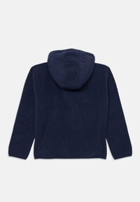 Felpa con cappuccio navy in fleece caratterizzata da un cappuccio ampio e maniche lunghe. Il tessuto ha una fitta morbida e un design semplice senza alcun motivo visibile.