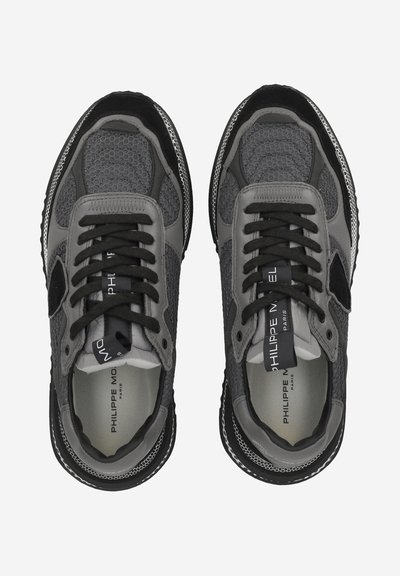 Sneaker sportive in mesh grigio con dettagli in suede nero. Presentano lacci piatti e suola in gomma. Brand visibile su una linguetta. Dettagli texturizzati.