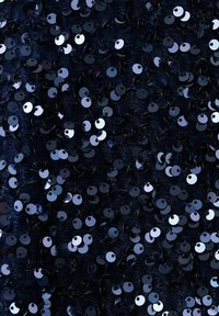 Čierna flitrová látka s rôznymi veľkosťami okrúhlych flitrov, ktoré odrážajú svetlo v odtieňoch modrej a strieborné, vytvárajúca textúrovaný, lesklý povrch.