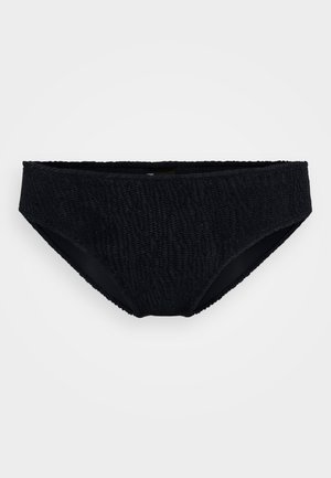 Bas de bikini noir en tissu texturé, taille haute et bords festonnés. Doublure intérieure lisse, avec un motif en vagues subtil sur la surface extérieure.