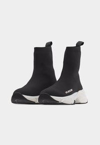 Μαύρα ψηλά αθλητικά παπούτσια-κάλτσες με λευκές χοντρές σόλες και τη μάρκα "LOVE MOSCHINO" στο πλάι, παρουσιασμένα σε λευκό φόντο.