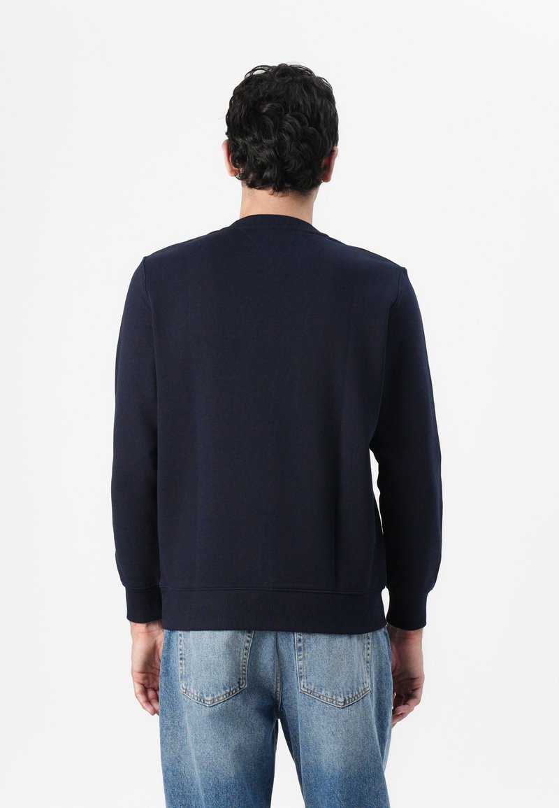 Felpa blu navy con collo a giro, polsini e orlo a coste. Realizzata in tessuto morbido, presenta un design semplice e pulito, senza motivi visibili.