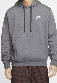 Šedá mikina s kapucí z měkké látky, s přední kapsou, nastavitelnou stahovací šňůrkou na kapuci a bílým logem Nike na levé straně hrudi.