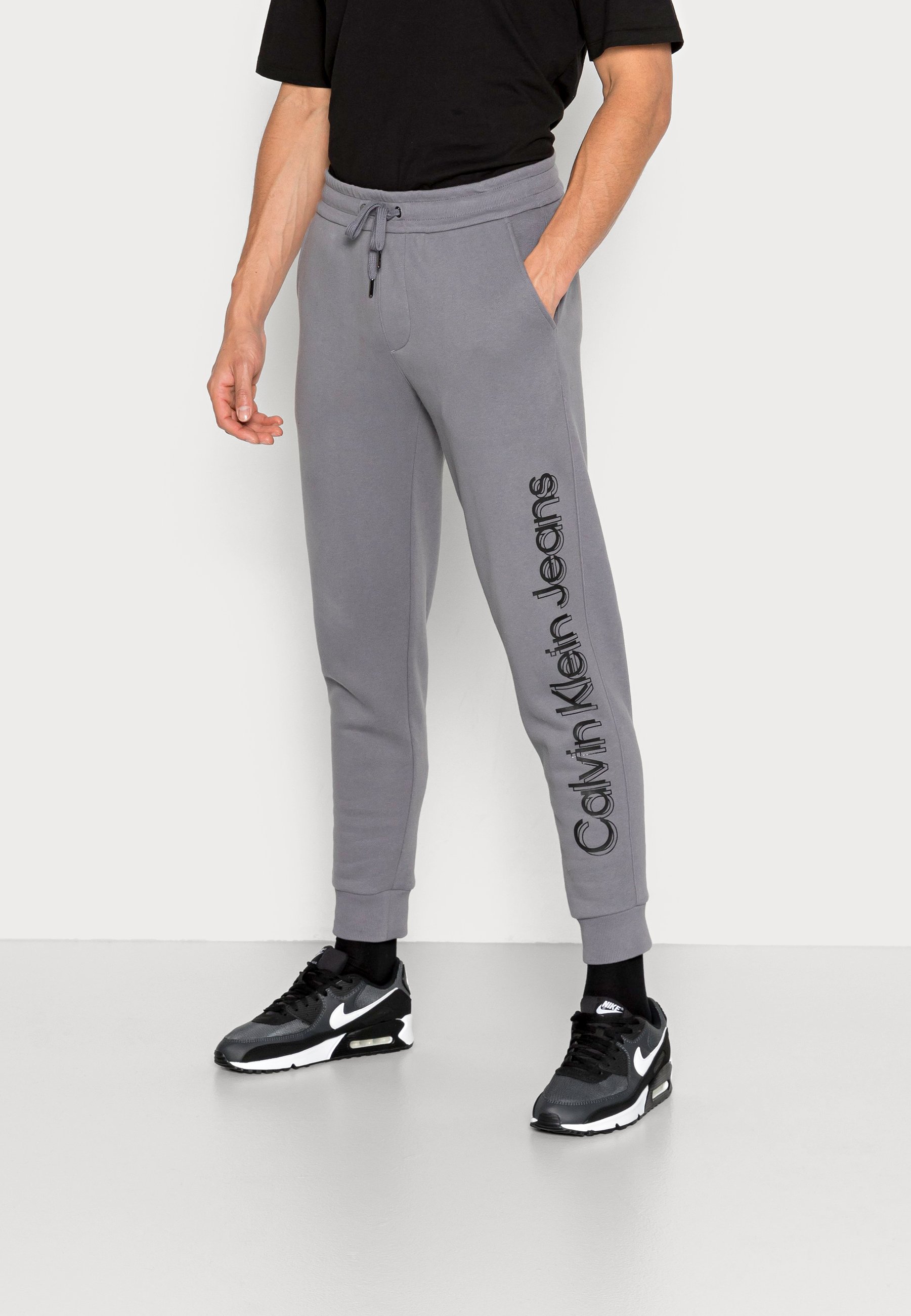 Calvin Klein Jeans VERTICAL BOLD INSTIT PANT - Pantaloni sportivi - fossil  grey/grigio scuro screziato - Zalando.it