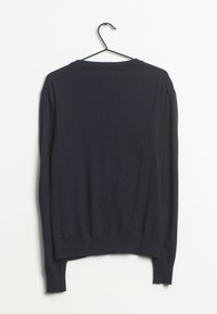 Marineblauer Strickpullover auf einem Bügel mit langen Ärmeln, Rundhalsausschnitt sowie gerippten Bündchen und Saum. Weiche Textur und schlichtes Design.