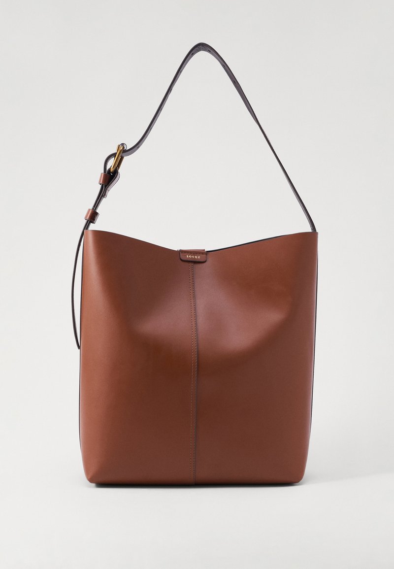 Borsa a spalla in pelle marrone con una texture liscia, corpo ampio, bordi superiori arrotondati e una sottile tracolla regolabile. Presenta una cucitura centrale.