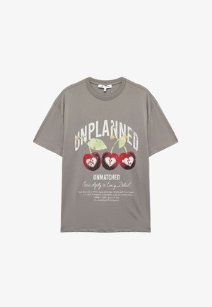 Grijze katoenen t-shirt met korte mouwen, voorzien van een grafische afbeelding van rode kersen en de tekst "UNPLANNED UNMATCHED" in het wit en groen.