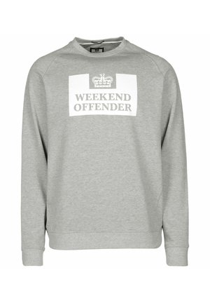 Harmaa collegepaita pitkällä hihalla, pyöreällä pääntiellä ja valkoisella suorakulmaisella kuvalla, jossa lukee "WEEKEND OFFENDER" sekä kruunukuvio.