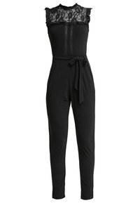 Combinaison noire sans manches avec empiècement en dentelle, épaules froncées, bandes verticales en dentelle sur le devant, taille haute et ceinture en tissu nouée.