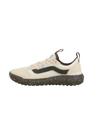 Zapatilla beige con acentos marrón oscuro y suela negra moteada. Presenta una parte superior de ante y malla, con cordones y una tira en la parte trasera.