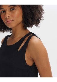 Schwarzes ärmelloses Tanktop mit einer sanften Textur, ausgestattet mit Schulterausschnitten und einem lockeren Schnitt. Keine Muster oder auffälligen Hardware-Elemente sichtbar.