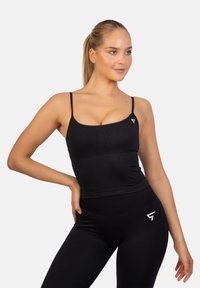 Czarny top do ćwiczeń z cienkimi ramiączkami, o dopasowanym kroju i logo na lewej piersi. Wykonany z elastycznego, gładkiego materiału.
