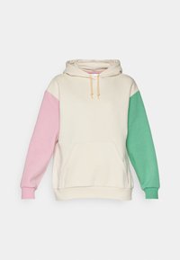 Hettegenser i krem med rosa og grønne ermer, med frontlomme og snor. Laget av myk, teksturert stoff.