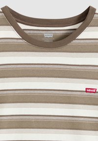 Καφέ και λευκό ριγέ T-shirt με στρογγυλή λαιμόκοψη και κόκκινο λογότυπο Levi's. Κατασκευασμένο από απαλό ύφασμα, με οριζόντιες γραμμές διαφορετικών πλάτων.