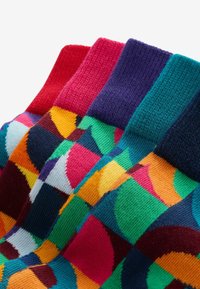 Chaussettes colorées avec un motif géométrique aux teintes vives, y compris le rouge, le rose, le vert et le bleu, avec des bords côtelés et une texture douce.