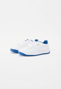 Valkoiset tennarit, joissa on siniset kumipohjat, rei'itetty muotoilu, pyöreä kärki ja valkoiset nauhat. Ominaisuuksiin kuuluu sininen sisus ja kultaiset logokuvioinnit.