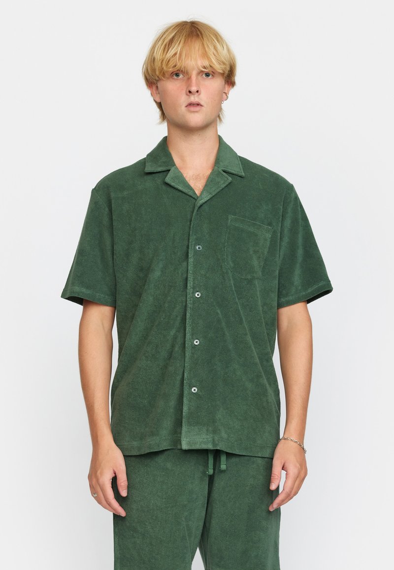 Korte mouwen, button-up shirt in donkergroen terrycloth, met een kraag, voorzak en een relaxte pasvorm. Zachte textuur met een subtiele glans.