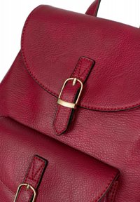Zaino in pelle rossa con una finitura testurizzata, dotato di un ribaltina arrotondata, fibbia in metallo dorato e dettagli di cucitura nera a contrasto.