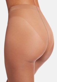 Sömlös, genomskinlig strumpbyxa i en ljusbrun färg, med en slät textur och hög midja, designad för en nära passform utan synliga linjer.