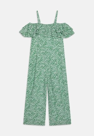 Combinaison florale verte avec des manches volantes dénudées, présentant une coupe ample et un tissu texturé avec des motifs blancs.