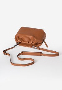 Bruine leren schoudertas met een geplooid ontwerp, ritsluiting en verstelbare schouderband. Heeft een gladde textuur en minimale accenten.