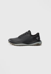 Black low-top sneaker with grey sole, lace-up front, and subtle wave patterns, featuring a small logo on the heel side.