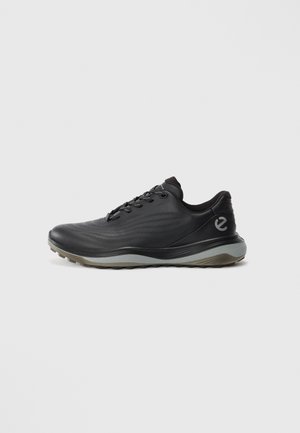 Black low-top sneaker with grey sole, lace-up front, and subtle wave patterns, featuring a small logo on the heel side.