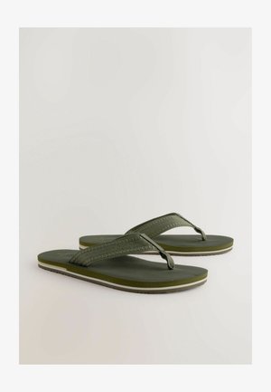 Tongs vertes avec des brides texturées, semelle en caoutchouc et accent blanc contrastant ; design plat adapté à une tenue estivale décontractée.