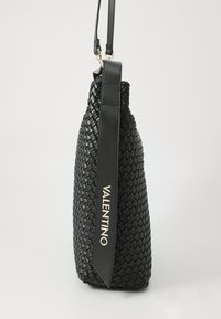 Borsa a mano in pelle intrecciata nera con una forma strutturata, dotata di una tracolla piatta e un accento in oro con il logo.