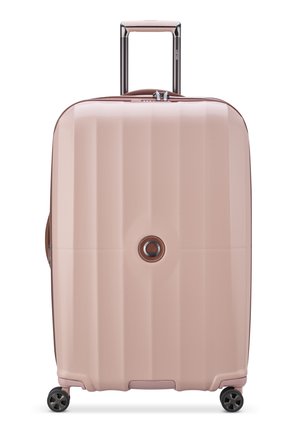 Hard-shell luggage in light pink with a textured finish, featuring a telescopic handle, rotating wheels, and a central logo detail.