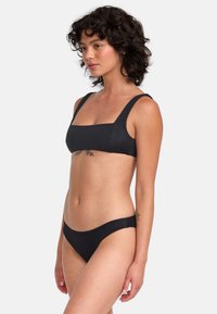 Ensemble de bikini noir comprenant un top à encolure carrée avec de larges bretelles et un bas taille basse assorti, fabriqué à partir d'un matériau lisse et extensible.