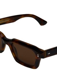 Lunettes de soleil en écaille de tortue marron avec un design carré massif. Elles présentent des verres sombres et rectangulaires, ainsi que des points d'accent en argent sur les branches.