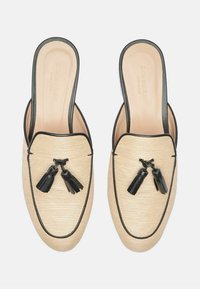 Bež cipele na slip-on s crnim naglascima, izrađene od teksturiranog materijala, okruglog oblika, s crnim detaljima u obliku rese sprijeda.