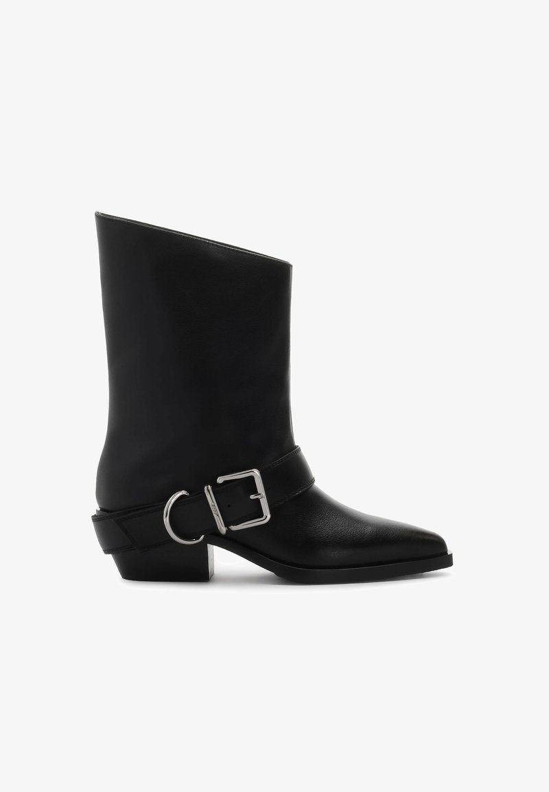 Mustmust ja musta nahast pahkluu saapad, millel on terav varvas, hõbedane kleepsuriba ja madal plokkheel. Sujuv tekstuur, millel on minimaalne kaunistus.