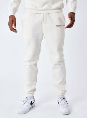Pantaloni della tuta bianchi realizzati in morbido tessuto, con vita regolabile tramite coulisse, polsini a costine e la scritta "PROJECT X PARIS" in grigio sul lato sinistro.