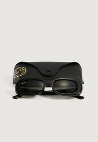 Gafas de sol Ray-Ban negras rectangulares con lentes oscuros colocadas frente a un estuche de cuero negro con una etiqueta dorada de Ray-Ban.