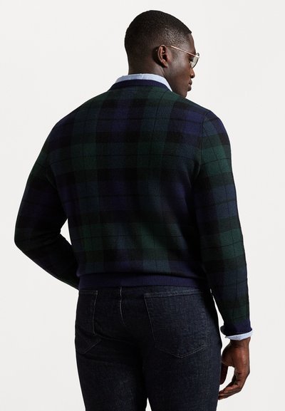 Suéter de punto a cuadros en verde oscuro y azul marino con un acabado texturizado, cuello y dobladillo acanalados, usado sobre una camisa de color azul claro con cuello.