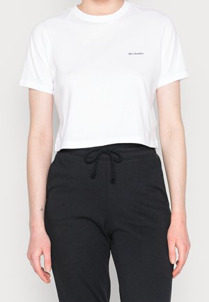 T-shirt blanc court à manches courtes, avec un petit logo Columbia bleu. Associé à un pantalon de survêtement noir à cordon de serrage.