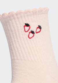 Lichtroze geribde sokken met een gegolfde bovenrand, versierd met drie geborduurde rode aardbeien met zwarte accenten. Zachte materiaalkwaliteit.