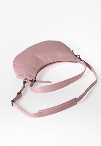 Borsa a tracolla in pelle rosa con design curvo, zip singola, tracolla regolabile e minimi dettagli in metallo. Texture liscia.