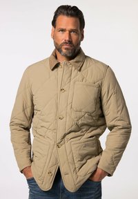 Giacca trapuntata beige con colletto in corduroy, bottoni frontali e due tasche laterali. Il materiale appare liscio con un design strutturato.