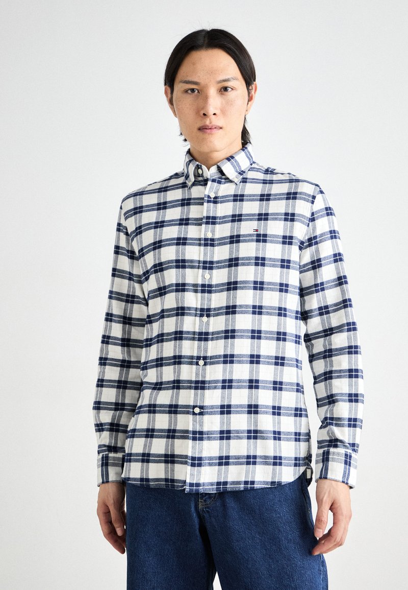 Ein Button-Down-Hemd mit einem blau-weißen Karomuster, aus einem strukturierten Stoff gefertigt. Lange Ärmel und ein gerader Saum mit dezenten Logo-Details.
