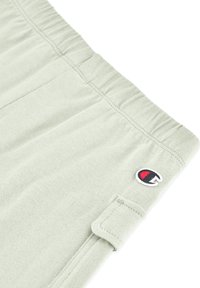 Hellegrüne Shorts mit elastischem Bund, genähtem Saum und Seitentaschen. Mit einem kleinen gestickten Logo auf der linken Seite.
