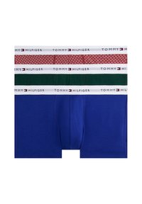 Tres bóxers: uno rojo con patrón geométrico, otro verde oscuro y otro azul, cada uno con una cintura blanca que lleva el logo "TOMMY HILFIGER".