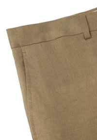 Un pantalon en lin marron clair avec une texture lisse, doté d'une taille plate et de coutures détaillées le long des joints.