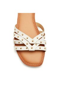 Sandal in ecopelle bianca con multiple cinghie incrociate e borchie dorate, dotato di una suola imbottita color tan e dettagli cuciti.