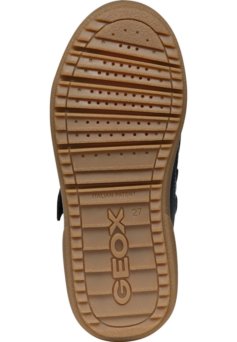 Semelle de chaussure noire avec une surface en caoutchouc texturée. Présente des arêtes et des rainures alternées, ainsi que les marquages "GEOX" et "PATENT ITALIEN."