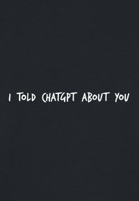 Tessuto nero con testo bianco disegnato a mano che recita "HO PARLATO DI TE A CHATGPT", centrato nel design. Il testo appare informale e casual.