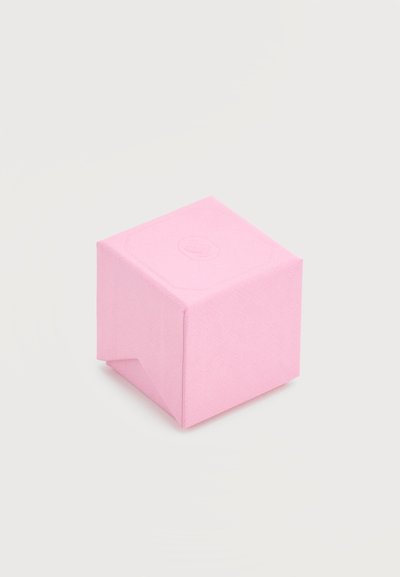 Cube en papier rose plié avec logo en relief sur le dessus, reposant sur une surface blanche.