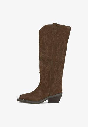 Botas de vaquero de gamuza marrón con cañas altas, puntas puntiagudas, patrones de hojas en relieve y un tacón bajo apilado. Acentuadas con costuras en contraste.